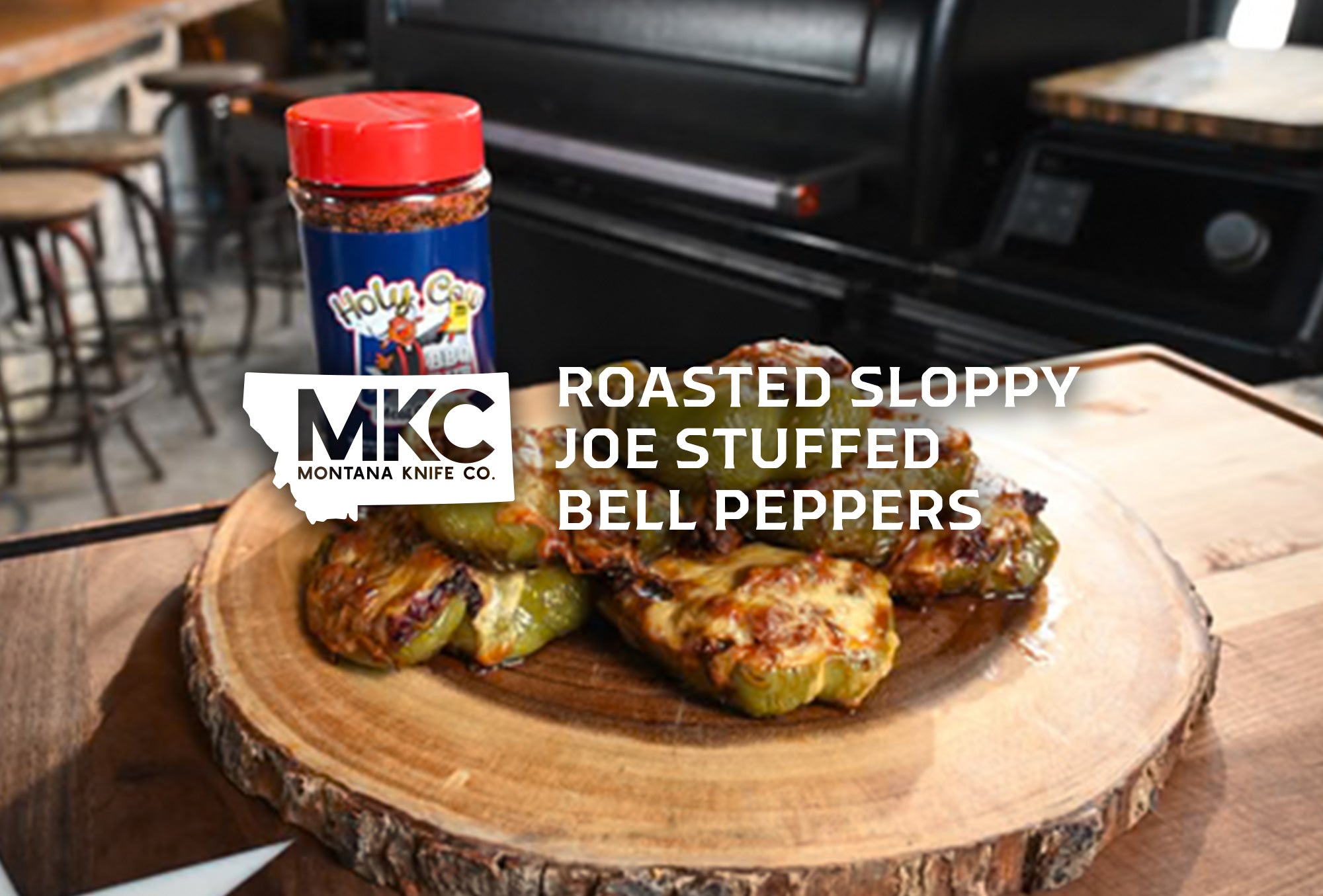 Roasted sloppy joe stuffed bell peppers on a wooden platter, with a seasoning jar.