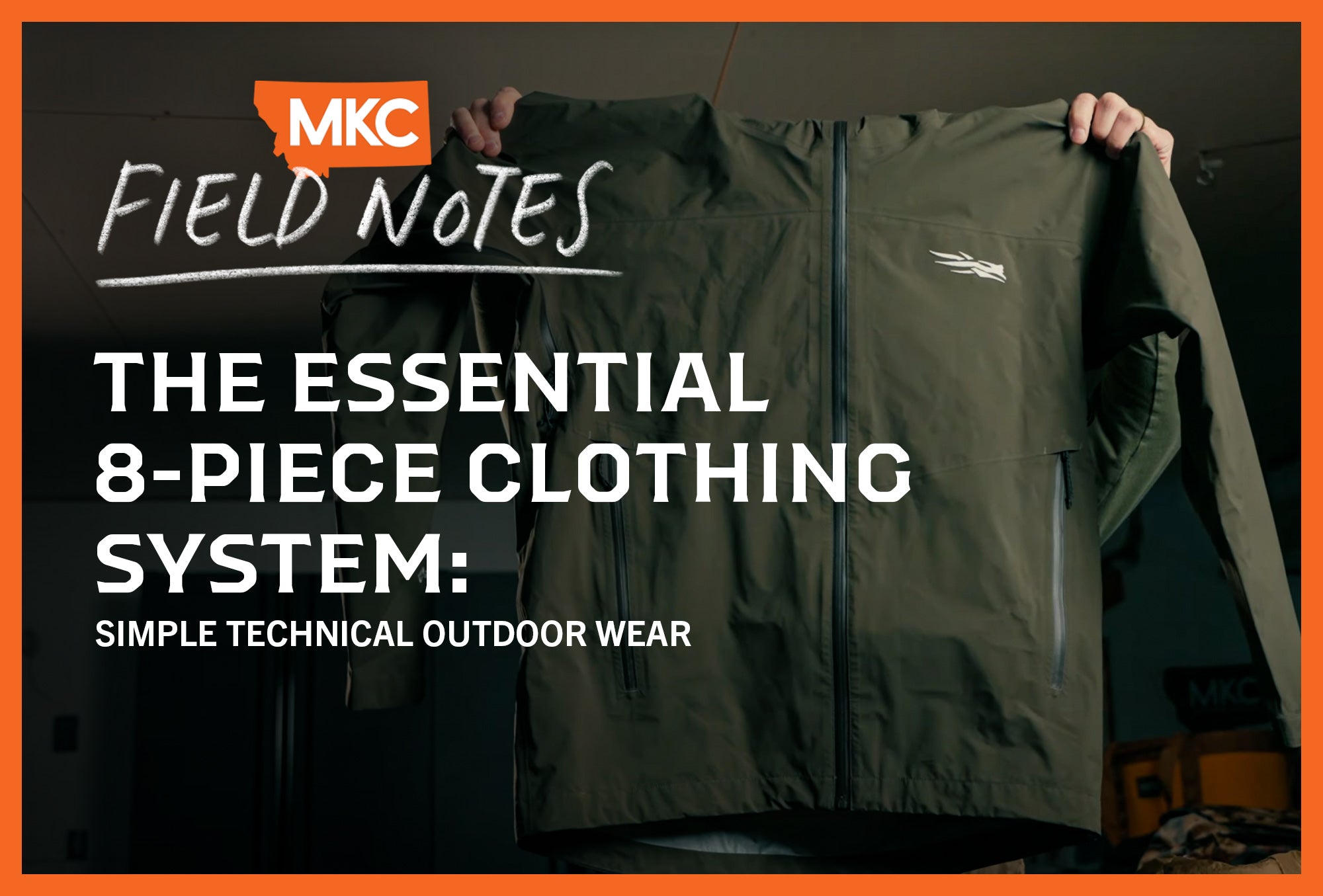 A green technical outdoor jacket is held up.